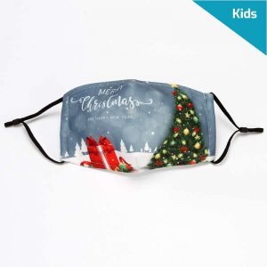 Light navy blue holiday mask for kids - composed of 3 layers of cotton, black elastic ear loops. The face mask has the words "Merry Christmas and a Happy New Year" printed in white. The foreground consists of a wrapped red christmas gift and a decorated christmas tree to the right. In the background, there are little white chritmas trees.